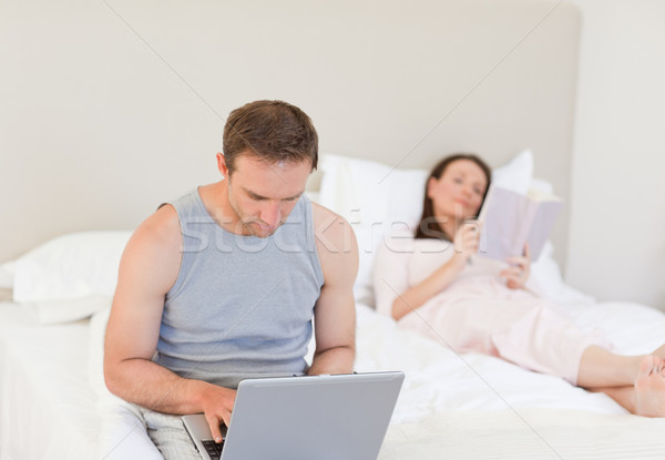 Mann arbeiten Laptop Ehefrau Lesung Buch Stock foto © wavebreak_media