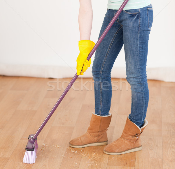 Stock photo: Attractive red-haired woman sweeping the floor at home