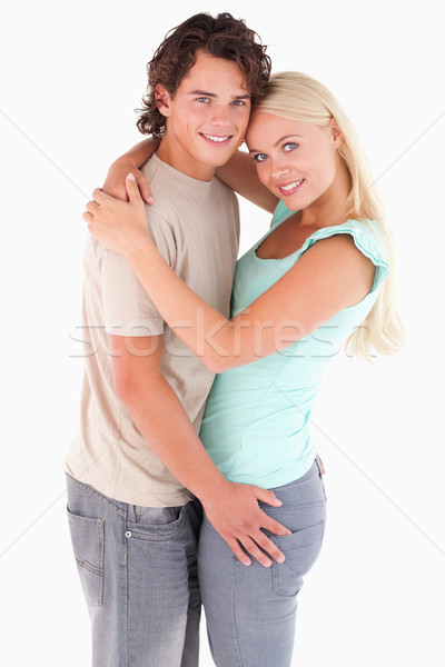 Stock photo: Hugging couple looking into the camera in a studio