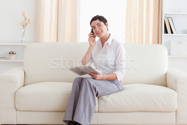 Bonitinho mulher celular jornal sala de estar casa Foto stock © wavebreak_media