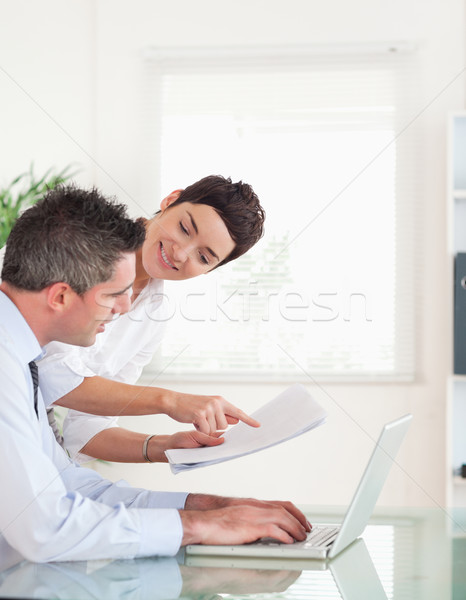 Stock photo: Portrait of coworkers comparing a blueprint folder to an electronic one in an office