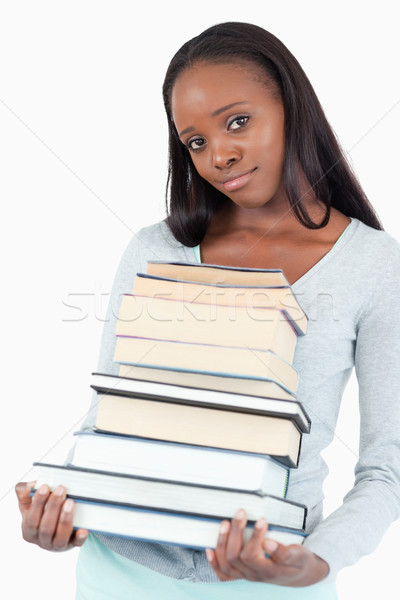 Stock photo: Sad smiling woman with pile of books against a white background