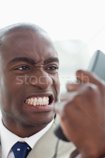 Portrait of an angry businessman looking at his phone handset in his office Stock photo © wavebreak_media