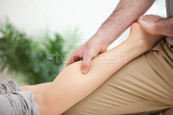 Man massaging the leg of a woman while placing it on his thigh in a room Stock photo © wavebreak_media