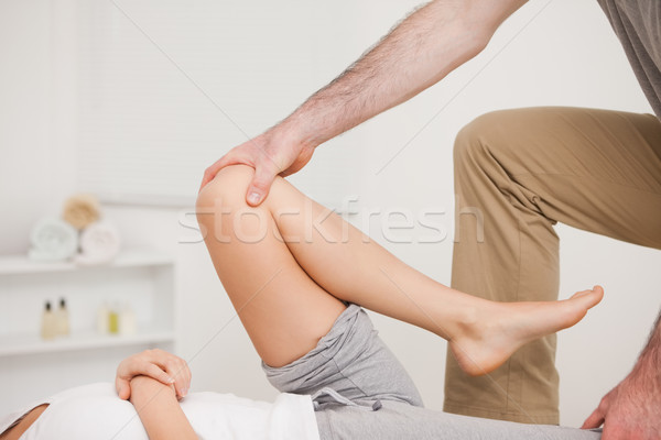 Osteopath working on a leg of a woman in a room Stock photo © wavebreak_media