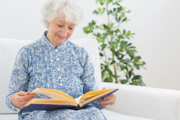 Stock photo: Elderly smiling woman looking at photos