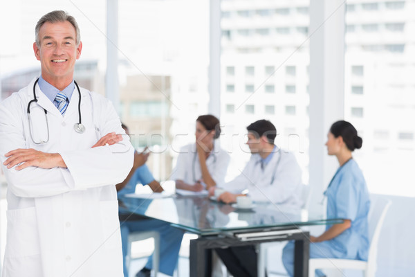 Doctor with group around table in background at hospital Stock photo © wavebreak_media