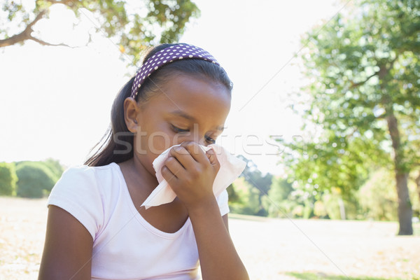Dziewczynka posiedzenia trawy dmuchanie nosa wiosną Zdjęcia stock © wavebreak_media
