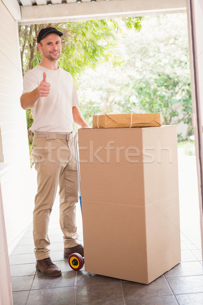 Delivery man with trolley of boxes giving thumbs up Stock photo © wavebreak_media