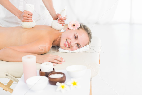 Stock photo: Beautiful blonde enjoying a herbal compress massage