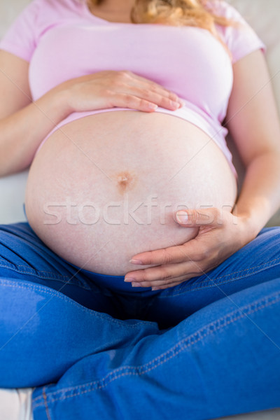 Közelkép terhes nő ül kanapé megérint has Stock fotó © wavebreak_media