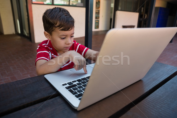 Cute boy working on digital laptop while sitting at table Stock photo © wavebreak_media