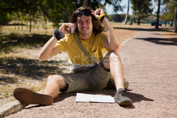 Stock photo: Tourist man with map talking on mobile phone