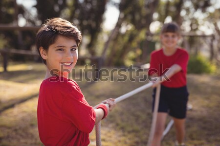 Determined boy practicing tug of war during obstacle course Stock photo © wavebreak_media