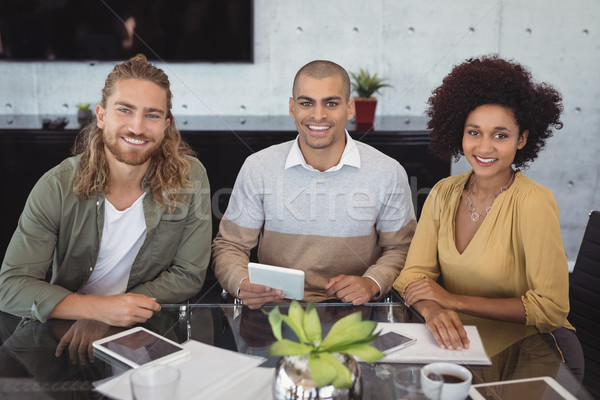 Portrait of smiling business colleagues sitting at office desk Stock photo © wavebreak_media