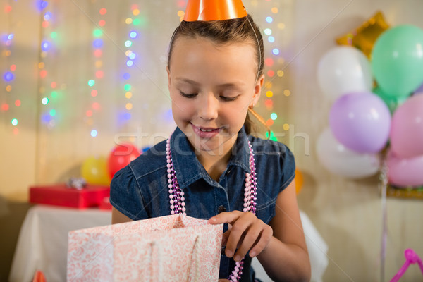 Girl looking at gift bag during birthday party Stock photo © wavebreak_media