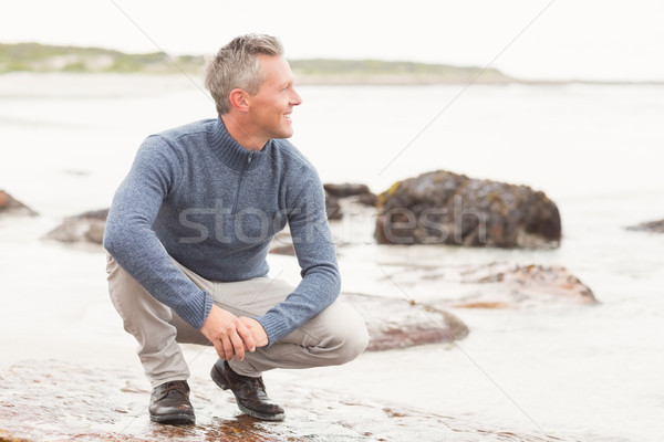 Man crouched down on a large rock Stock photo © wavebreak_media