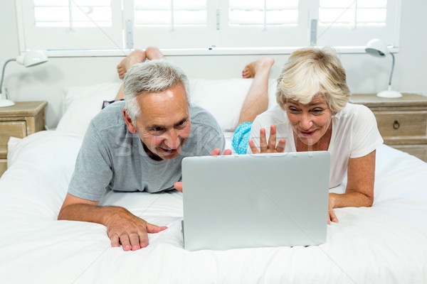 Senior man and woman using laptop on bed at home Stock photo © wavebreak_media