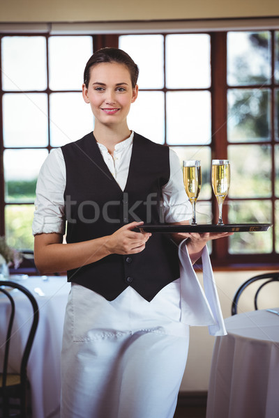 Portrait of waitress holding serving tray with champagne flutes& Stock photo © wavebreak_media