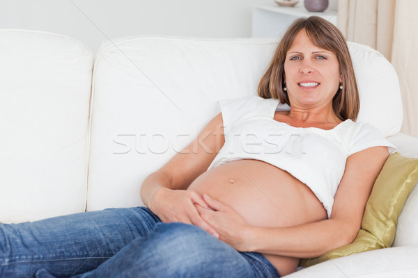 Beautiful pregnant woman posing while lying on her sofa Stock photo © wavebreak_media