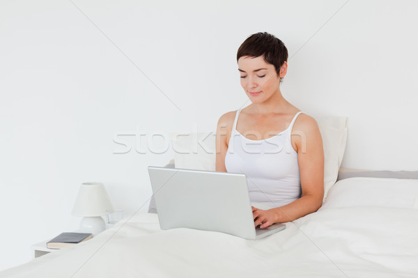 Stockfoto: Charmant · brunette · met · behulp · van · laptop · slaapkamer · computer · meisje