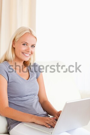 Portrait of a blonde woman using a laptop while looking at the camera Stock photo © wavebreak_media
