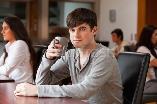 Young man having a coffee while looking at the camera Stock photo © wavebreak_media