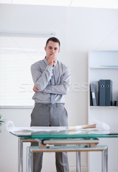 Stock photo: Businessman standing behind table and thinking