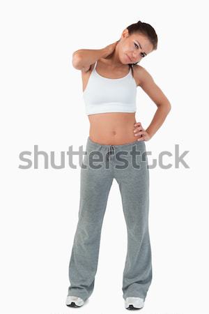 Young woman with pain in her neck against a white background Stock photo © wavebreak_media