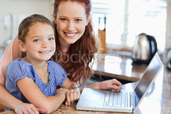Mother and daughter together with notebook in the kitchen Stock photo © wavebreak_media