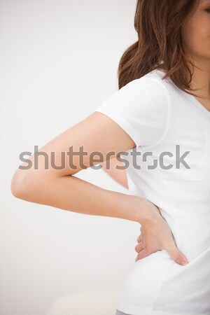 Woman massaging her painful back in a medical room Stock photo © wavebreak_media