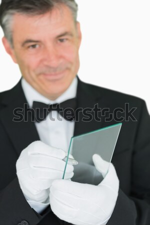 Waiter looking at the camera while holding a silver tray on white background Stock photo © wavebreak_media