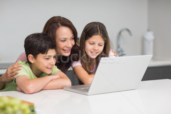 Sorridere madre ragazzi utilizzando il computer portatile cucina giovani Foto d'archivio © wavebreak_media