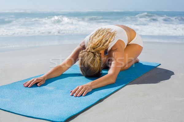 Gorgeous fit blonde in childs pose on the beach Stock photo © wavebreak_media