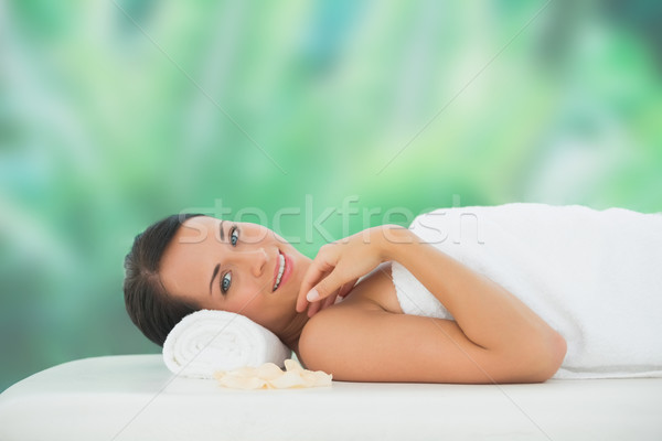 Beautiful brunette relaxing on massage table smiling at camera Stock photo © wavebreak_media