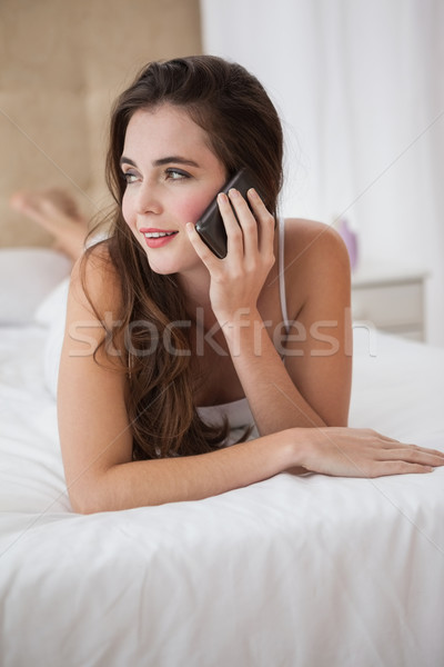 Destul de bruneta vorbesc telefon pat acasă Imagine de stoc © wavebreak_media