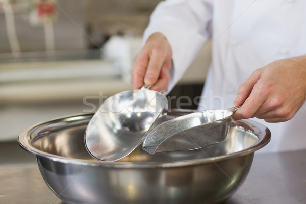 Baker holding scoops over bowl Stock photo © wavebreak_media