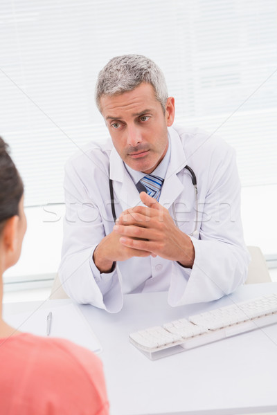 Stock photo: Patient consulting a serious doctor 