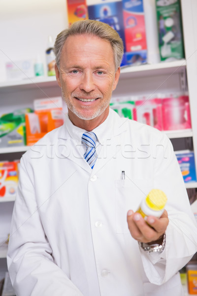 Smiling senior pharmacist holding medicine jar Stock photo © wavebreak_media