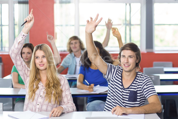 Students raising hands in classroom Stock photo © wavebreak_media