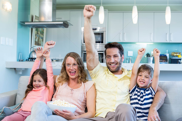 Stock photo: Happy family on the couch watching tv