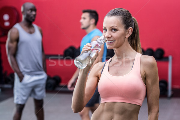 Uśmiechnięty muskularny kobieta woda pitna portret wody Zdjęcia stock © wavebreak_media