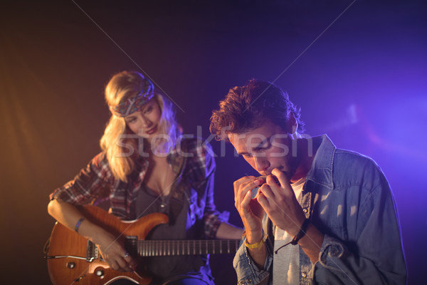 Guitarist looking at musician playing harmonica in music concert Stock photo © wavebreak_media