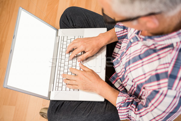 Casual man sitting and working with laptop Stock photo © wavebreak_media