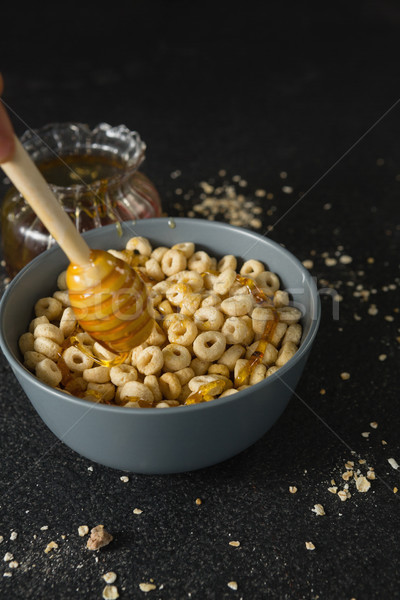 Honey being poured in bowl of cereal rings Stock photo © wavebreak_media