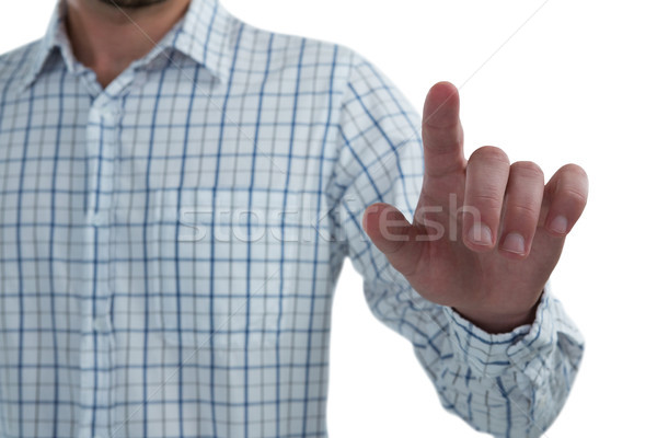 Man pretending to touch an invisible screen against white background Stock photo © wavebreak_media