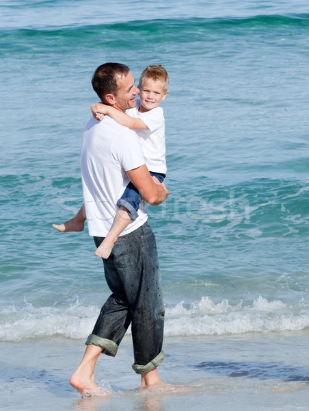 Cute little boy and his father walking on the sand Stock photo © wavebreak_media