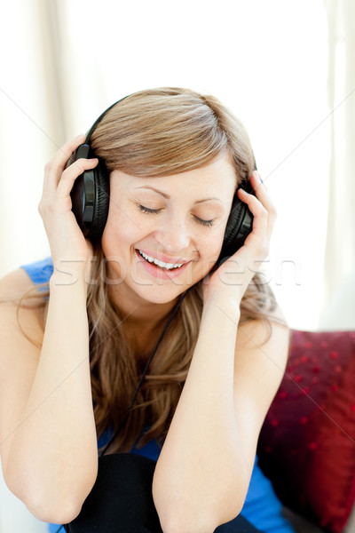 Stock photo: Beautiful woman is listening the music in the living-room 