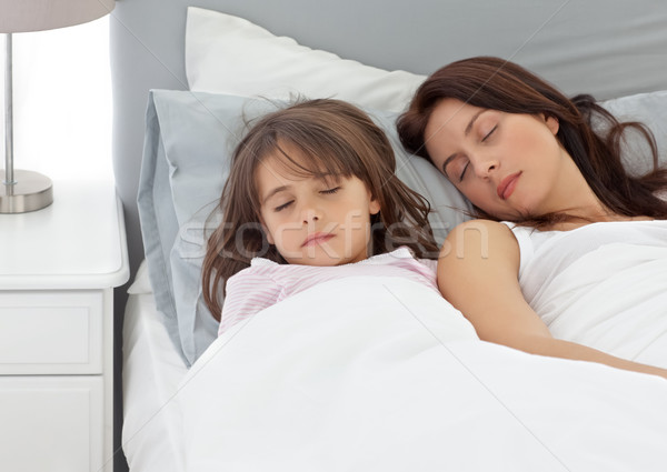 Cute little girl sleeping with her mother in the morning at home Stock photo © wavebreak_media