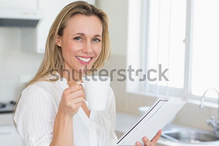 Close up of a smiling dark-haired woman having a coffee in her kitchen Stock photo © wavebreak_media